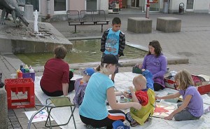 Kinder mit Malsachen auf einem Platz