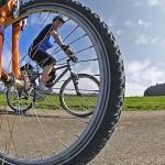 Blick durch Fahrrad mit Speichen auf Radfahrerin