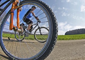 Blick durch Fahrrad mit Speichen auf Radfahrerin