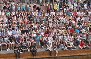 Sehr viele Menschen sitzen eng gedrängt nebeneinander