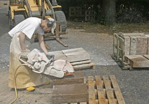 Mann schneidet Sandsein mit Maschine