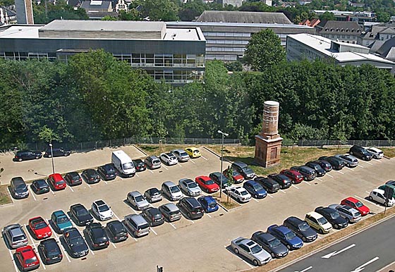 Blick vom Parkhaus Pilgrimstein auf den jetzigen Pakrplatz auf dem vormaligen Gelände der Marburger Baurerei, an die alleine noch der Schornsteinstummel erinnert. Hinter dem Mühlgraben Hörsaalgebäude und Uni-verwaltungsgebäude. Foto Hartwig Bambey