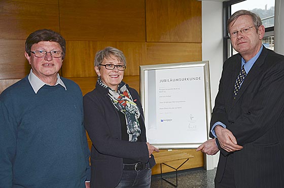 Barbara Eiffert von der Handwerkskammer in Kassel überreichte Universitätskanzler Dr. Friedhelm Nonne die Urkunde zum Betriebsjubiläum der Philipps-Universität Marburg, die vor 50 Jahren offiziell in die Lehrlingsrolle eingetragen wurde. Foto: nn Pressestelle Philipps-Universität Marburg.