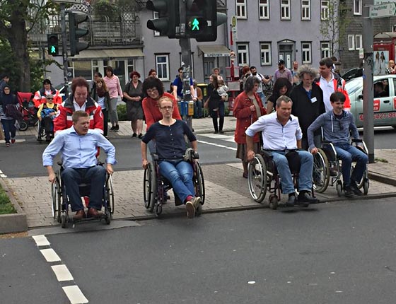 Drei Kandidaten und eine Kandidatin für die Oberbürgermeisterwahl bei der Fahrt mit dem Rollstuhl, als sie erlebten, wie schwierig es ist, am Erlenring die Straße zu überqueren. Foto nn