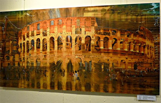 Brauntöne prägen Werner Eismanns 'Colosseo Roma Hot Night 30 Grad'. In dem stimmungsvollen Fotocomposing mit einer Zentralperspektive bevölkern Menschen die Platz vor dem Rundbau, in dem sich zugleich das Bauwerk spiegelt. Sternbald-Foto Hartwig Bambey