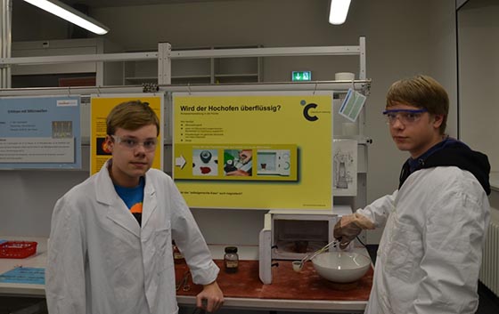 Max Kaireit (links) und Thomas Ried von der Gesamtschule Ebsdorfergrund stellten mit einer Mikrowelle aus Eisenoxid und Aktivkohle kleine Mengen Eisen her. Foto: Provadis