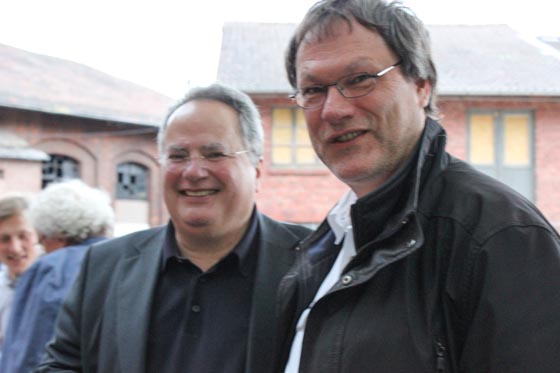 Der griechische Außenminister Nikolaos Kotzias beim Besuch in Marburg am 31. Mai 2015 lacht zusammen mit Johannes Linn in die Kamera.