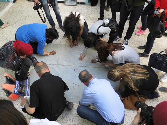 „Reconciliation“ (Versöhnung): Hunderte von Menschen in der Marburger Partnerstadt Sfax haben sich bereits mit ihren Ideen und Antworten an der Aktion von Thomas Gebauer beteiligt - hier beim Beschreiben der Plastikplane. Foto Thomas Gebauer